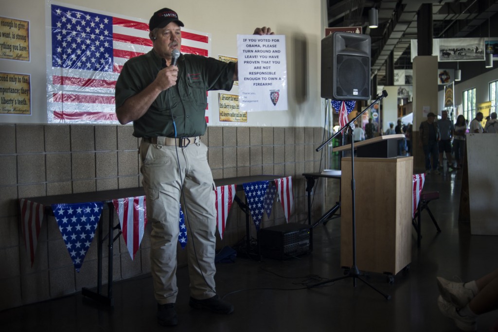 Cope Reynolds, operations manager at Shots Ranch in Arizona, shows a sign that he posted on his gun shop after the 2012 election. (Photo by Jim Tuttle/News21)